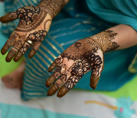 Woman Hand with black mehndi tattoo. Hand of Indian bride girl with black henna tattoos. Showing empty copy space on the open hand.